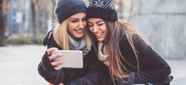 Två tjejer som tar en selfie och umgås